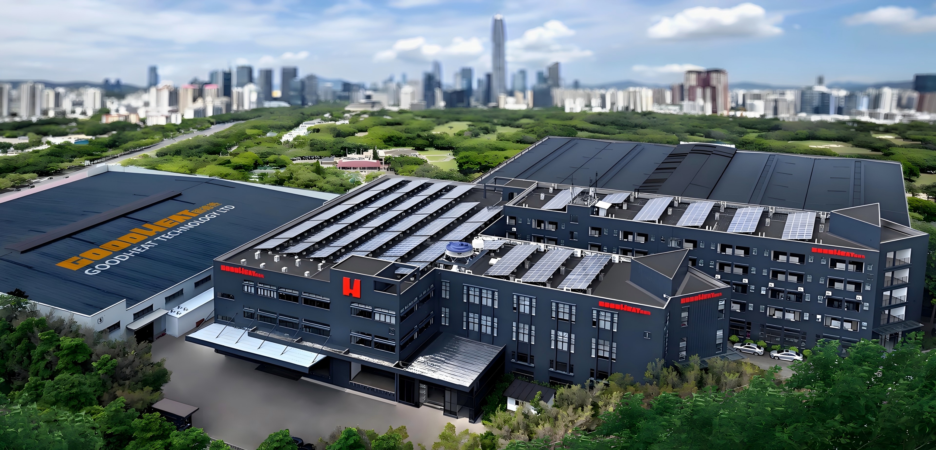 GOODHEAT Technology production base in Shunde, featuring modern factory buildings with rooftop solar panels and surrounding greenery, with the city skyline visible in the background